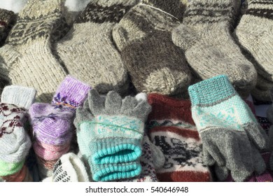 Many Warm Woolen Socks And Gloves On The Counter 