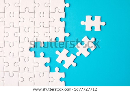 Many white jigsaw puzzle on blue background - idea solution concept.