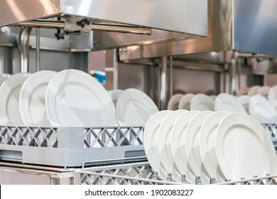 Many White Plate On Basket In Automatic Dishwasher Machine For Cleaning In Kitchen Room Restaurant