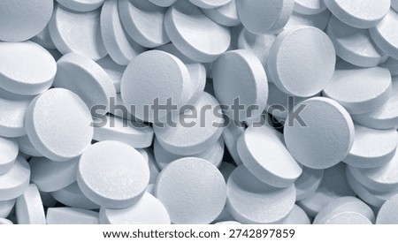 Many white tablets as a solid texture pharmaceutical medical background