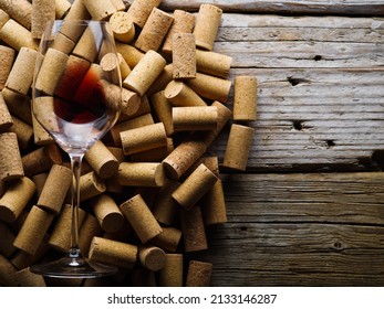 Many Wine Corks, Wine Glass On A Wooden Background. There Are No People In The Photo. Celebration, Romantic Date, Restaurant, Hotel, Wine Collection, Winemaking, Banner.