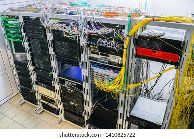 Many Wires Intertwine On Top Of Server Cabinets. Racks With Internet Telecommunications Equipment Are In The Server Room. Modern Computing Data Center View From Above.