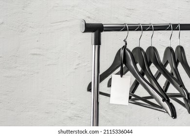 Many wooden black hangers on a rod a white background.Store concept, sale, design, empty hangers.Wooden hanger for clothes. Place for text.