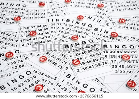 Many wooden chips with numbers and cards for a board game of bingo or lotto on a light background. Russian Lotto has similar rules to the classic worldwide bingo game.