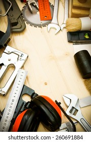 Many working tool. The different working tools (plane, saw, mallet, stapler and others) on a wooden background.