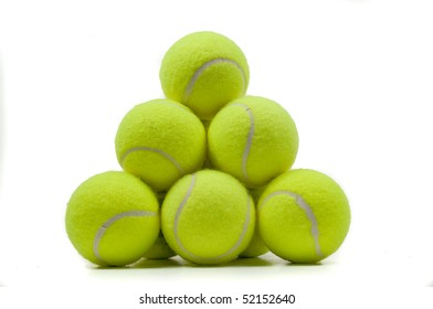 Many Yellow Tennis Balls Stacked Together Over White