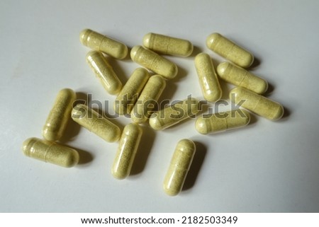 Many yellowish green capsules of quercetin dietary supplement from above