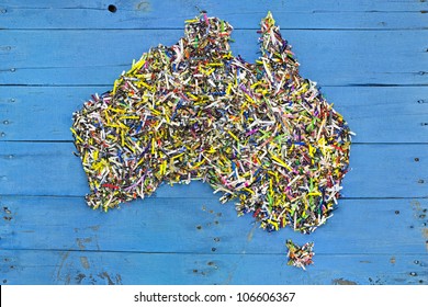 Map of Australia made out of recycled shredded paper on rustic blue boards.