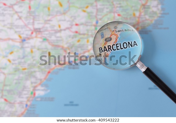 Map of Barcelona consulted with a\
magnifying glass highlighting the name of the\
city