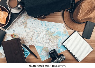 Map, Coffee, Toast, Camera, Hat, Book, and Pen on the table. Tourist planning vacation-holiday with  map. 