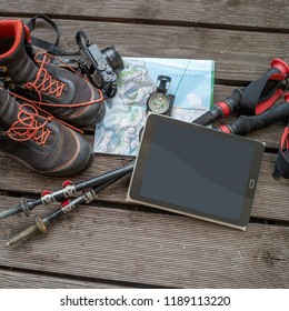 Map, compass, camera, touchpad and hiking poles and boots for traveling, paste space, gears, tools