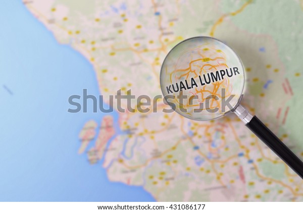 Map of Kuala Lumpur consulted with a\
magnifying glass highlighting the name of the\
city