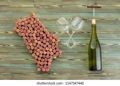 Map Of Napa Valley Made Of Used Red Wine Bottle Corks Arranged On Rustic Wood With Crossed Empty Wineglasses And A White Wine Bottle With Corkscrew