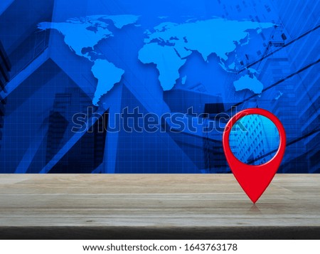 Map pin location button on wooden table over world map, modern city tower and skyscraper, Map pointer navigation online concept, Elements of this image furnished by NASA