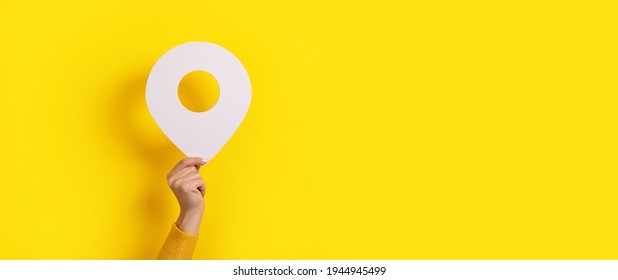 map pointer 3d pin in hand over yellow background - Shutterstock ID 1944945499