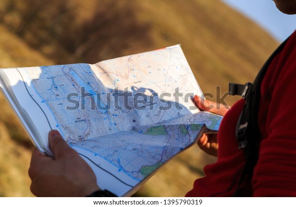 Map reading in the\
wilderness by young man