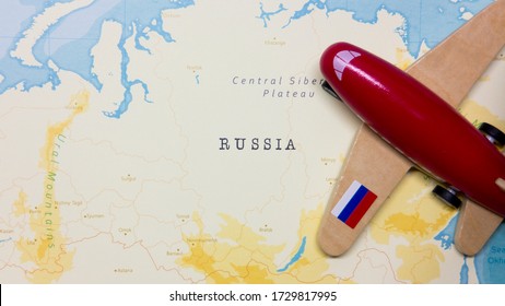 A Map Of Russia And A Red Plane With A Flag Of Russia Attached To Its Wings.