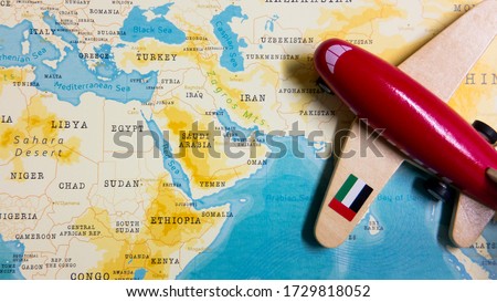 A map of United Arab Emirates and a red plane with a flag of United Arab Emirates attached to its wings.
