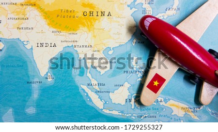 A map of Vietnam and a red plane with a flag of Vietnam attached to its wings.