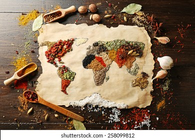Map of world made from different kinds of spices on wooden background
