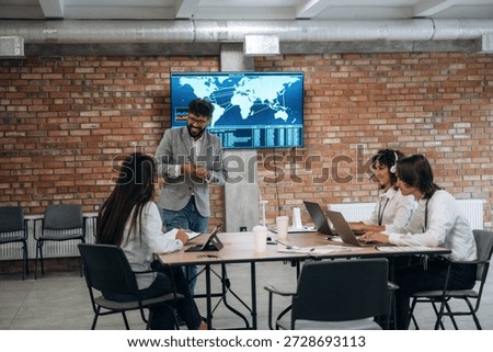 Map of the world on the screen. Four office workers are together, employees at work.