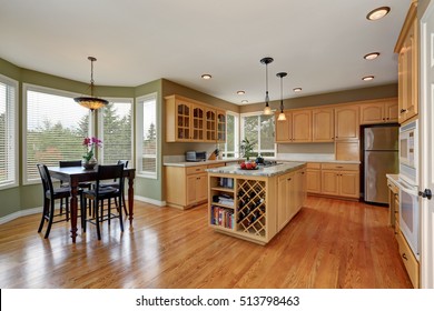 Maple Cabinets And Large Kitchen Island With Book Shelves And Storage Units For Wine. Kitchen Room Interior. Dining Table Set. Northwest, USA