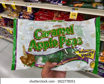 Maple Grove, Minnesota - September 14, 2020: Hand Holds Up A Bag Of Caramel Apple Pops Suckers, Packaged For Halloween Trick Or Treating, At A Grocery Store