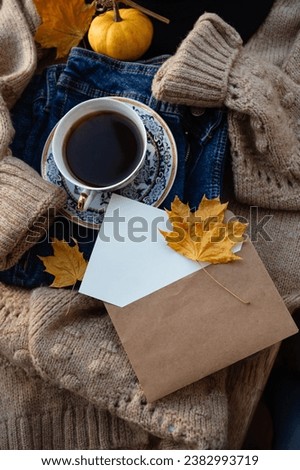Maple leaf in an envelope. Blank sheet for text. Place for inscription postcard. Autumn composition of dried orange maple leaves, tea, envelope and candle. Autumn and Thanksgiving concept.