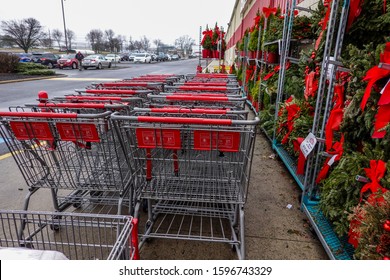 Maple Shade, New Jersey - December, 2019: Rows Of Wet Shopping Carts Near Display Of Christmas Ferns In Front Of A BJS Wholesale Club Store On A Rainy Day