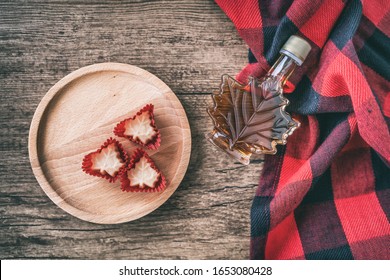 Maple Syrup Bottle From Quebec With Gift Candy Soft Sugar Top View On Rustic Wooden Background For Tourist Souvenir. Canada Grade A Amber Sweet Natural Liquid From Sugar Shack Maple Trees Farm.