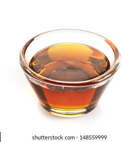 Maple syrup in a bowl on white background