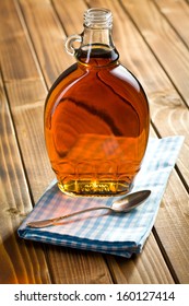 Maple Syrup In Glass Bottle On Wooden Table