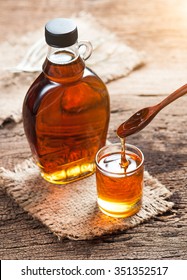 Maple Syrup In Glass Bottle On Wooden Table