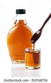 Maple Syrup In Glass Bottle On White Background