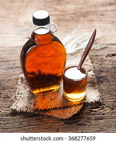 Maple Syrup In Glass Bottle On Wooden Table