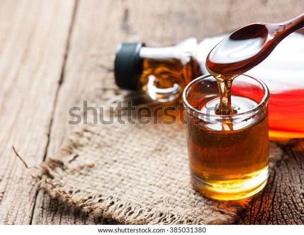 maple syrup in\
glass bottle on wooden\
table