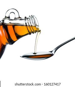 maple syrup pouring on spoon on white background