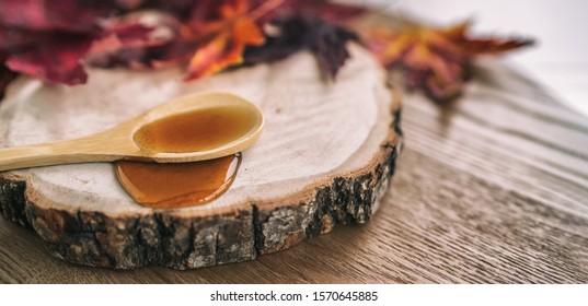 Maple syrup sugar shack cabane a sucre restaurant from Quebec farm maple tree sap famous sweet liquid dripping from wooden spoon on wood log rustic sugar shack banner panoramic with red leaves.