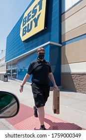 MAPLEWOOD, MINNESOTA / USA - JUNE 08, 2020: Masked Best Buy Employee Delivering Boxed TV To Car Practicing Social Distancing Due To The Covid-19 Pandemic. 