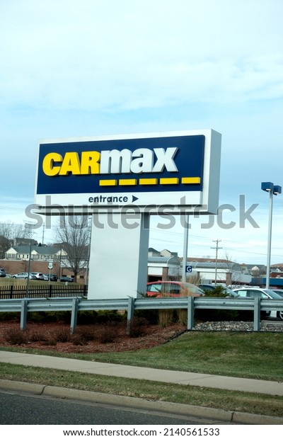 MAPLEWOOD, MINNESOTA USA - NOVEMBER 24,\
2019: Large sign with arrow directing you to the CarMax place of\
business and used car lot specializing in online\
sales.