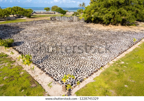 Marae Taputapuatea temple complex. Ancient stone\
carved sacred tiki (idol statue) and ahu altar. Raiatea island.\
Leeward / Society Islands, French Polynesia, Oceania, South Pacific\
Ocean. Aerial view.