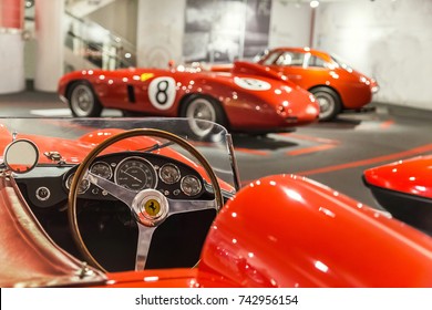 Maranello, Italy - July 26, 2017: Exhibition in the famous Ferrari museum (Enzo Ferrari) of sport cars, race cars and f1. Dashboard and steering wheel of red vintage classic sport, race car. Close up.