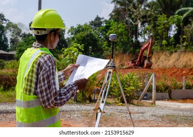 Marang, Malaysia-March 21,2022: A land surveyor looking at the construction planner on the site