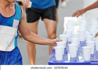 Marathon Runner Picking Up Water At Service Point