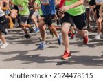 Marathon runners crowd, sportsmen participants start running the half-marathon in the city streets, crowd of sportswomen joggers in motion, group athletes outdoor training competition in summer day