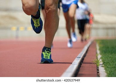 Marathon runners.Marathon with the aim of the stadium,running on the athletics track - Powered by Shutterstock