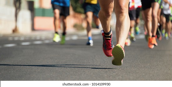 Marathon running in the light of evening,running on city road detail on legs.Copy space - Shutterstock ID 1014109930