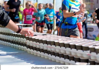 Marathon running race, runners on road, volunteer giving water and isotonic drinks on refreshment point
 - Powered by Shutterstock