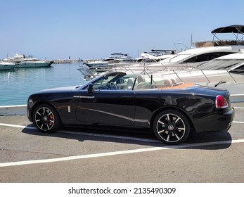 Marbella Malaga Spain June 12 2021. A Rolls Royce parked in the Puerto Banus harbor. Rolls Royce cabriolet car in the famous marina in Puerto Banus Marbella. Many yachts docked in the port.