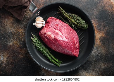 Marble beef raw, on frying iron pan, on old dark rustic background, top view flat lay